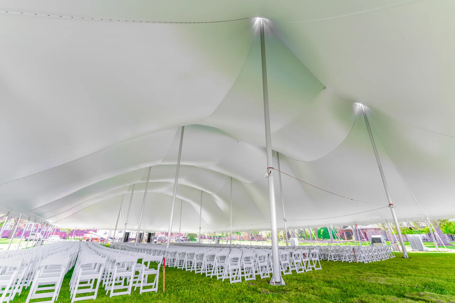 Interior view of the tensioned fabric ceiling and center poles of a high tension fabric tent